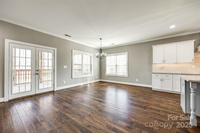 unfurnished dining area featuring french doors, dark wood finished floors, visible vents, and crown molding