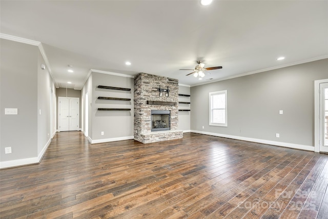 unfurnished living room featuring dark wood-style floors, a stone fireplace, and crown molding