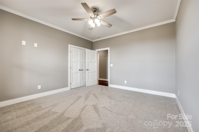 unfurnished bedroom featuring carpet floors, baseboards, and crown molding