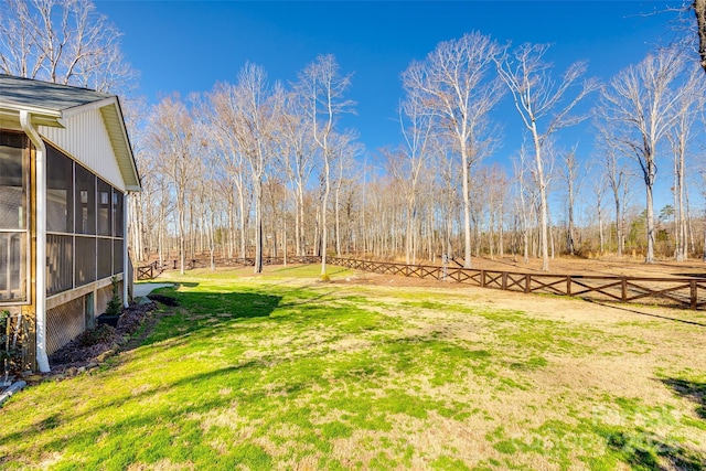 view of yard with a sunroom and fence