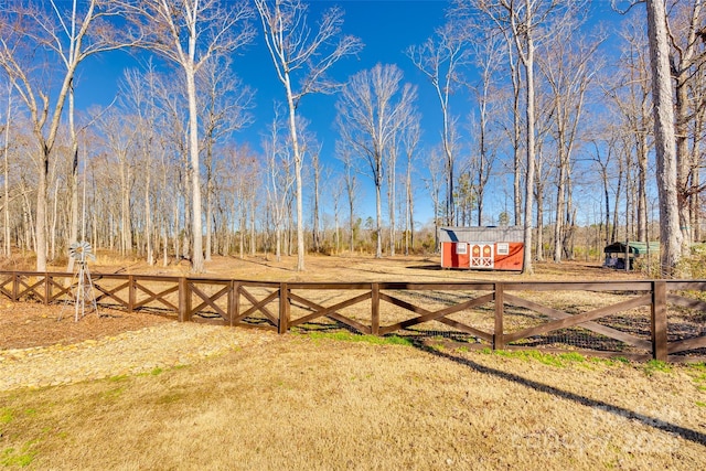 view of yard with an outbuilding, a shed, and fence