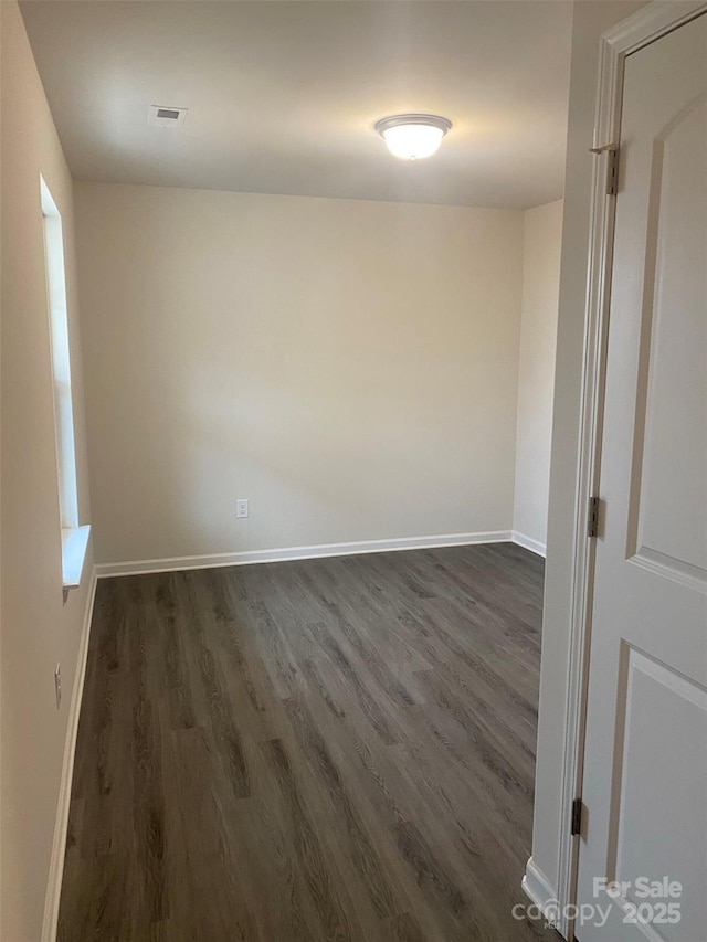 spare room with dark wood-type flooring