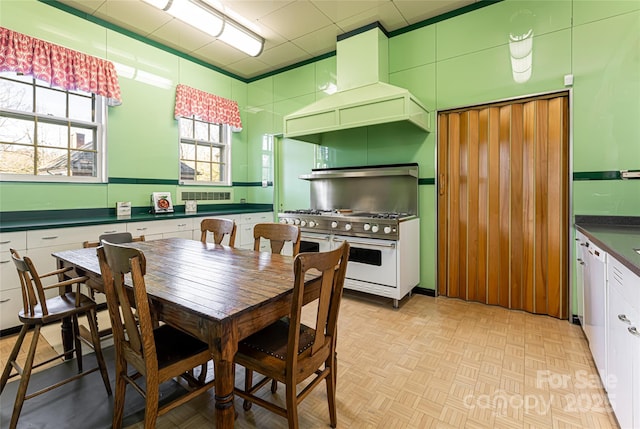 kitchen with premium range hood, range with two ovens, dark countertops, and white cabinets