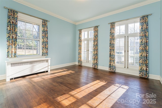 unfurnished room with ornamental molding, dark wood finished floors, a wealth of natural light, and radiator