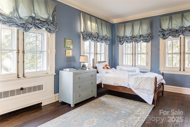 bedroom with radiator, wallpapered walls, baseboards, and dark wood-style floors