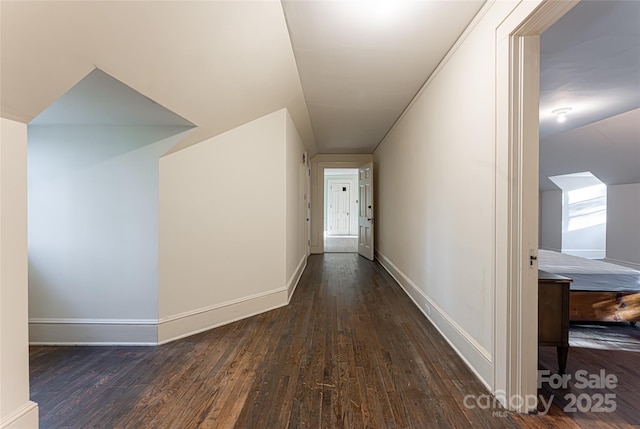 corridor featuring dark wood-style floors and baseboards