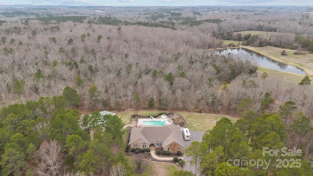 birds eye view of property with a water view and a forest view