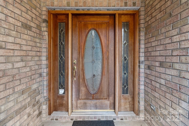 property entrance featuring brick siding