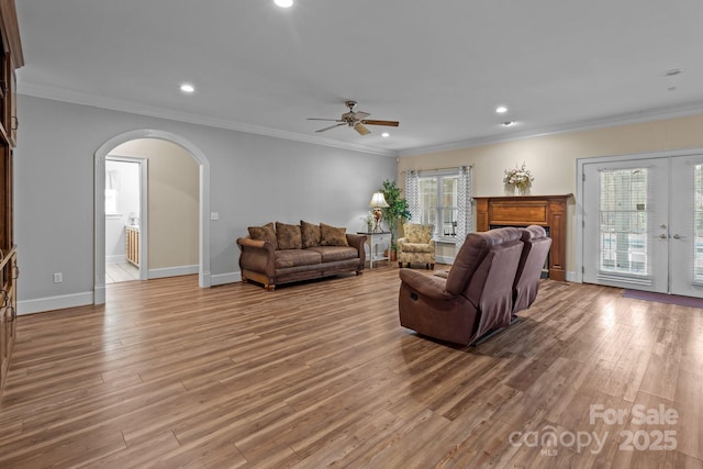 living area with arched walkways, french doors, wood finished floors, and a wealth of natural light