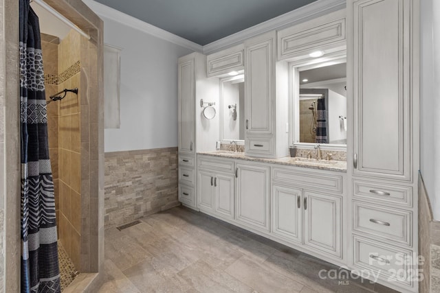 bathroom featuring tiled shower, a sink, tile walls, and double vanity