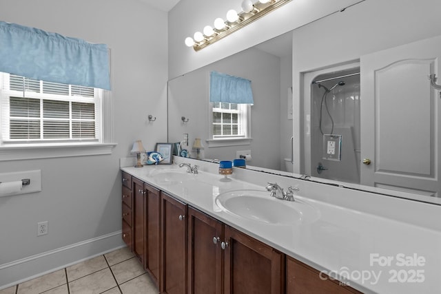 full bath featuring double vanity, a sink, toilet, and tile patterned floors