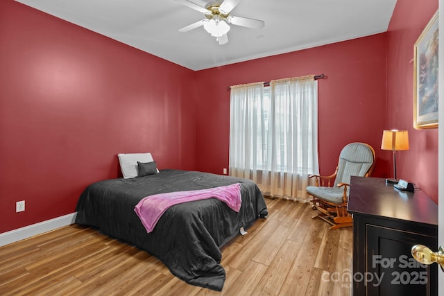 bedroom with ceiling fan, baseboards, and wood finished floors