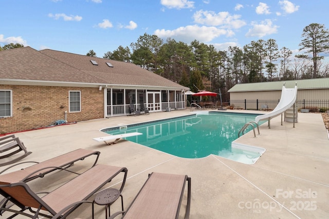 view of pool with a fenced in pool, a sunroom, a patio area, fence, and a water slide