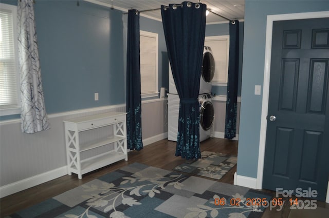 bedroom with dark hardwood / wood-style floors and stacked washer / dryer