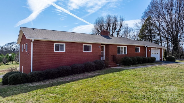 ranch-style home with aphalt driveway, brick siding, a chimney, an attached garage, and a front yard