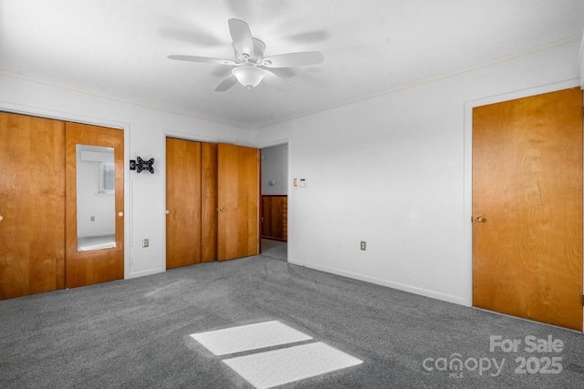 unfurnished bedroom featuring ornamental molding, carpet flooring, baseboards, and a ceiling fan