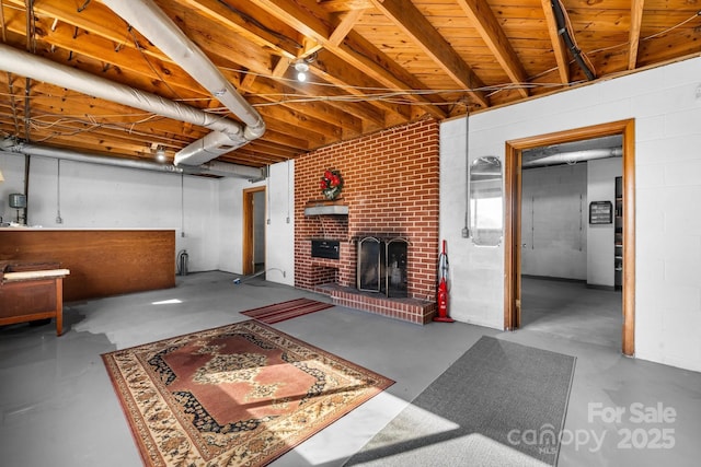 basement featuring a brick fireplace and concrete block wall