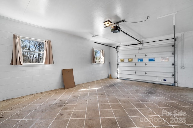 garage with a garage door opener and concrete block wall