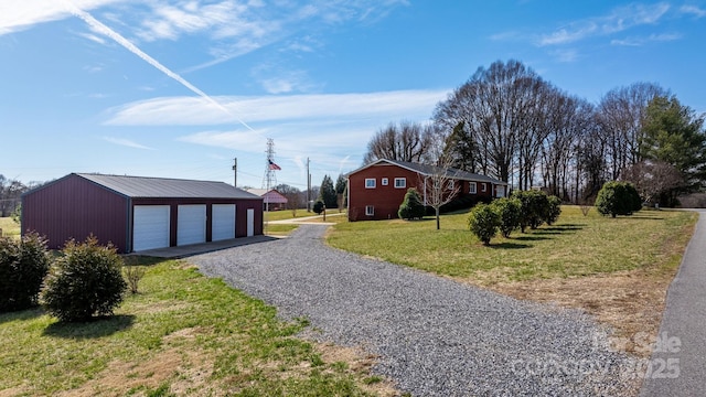 view of yard with an outbuilding, gravel driveway, and a garage