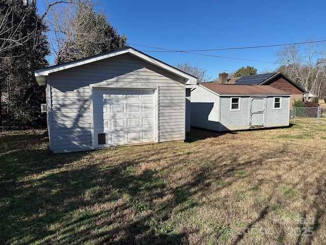 garage featuring a yard and solar panels