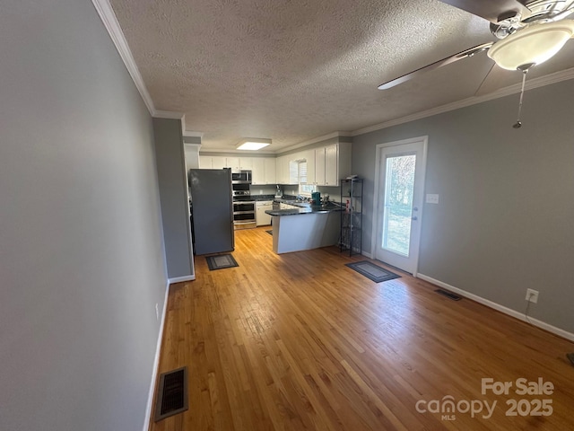 kitchen with crown molding, light hardwood / wood-style flooring, ceiling fan, appliances with stainless steel finishes, and white cabinetry