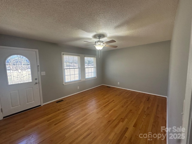 entryway with ceiling fan, hardwood / wood-style floors, and a textured ceiling