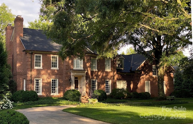 colonial home featuring a front lawn