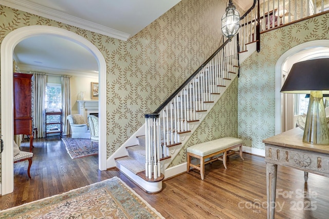 staircase with crown molding and hardwood / wood-style floors