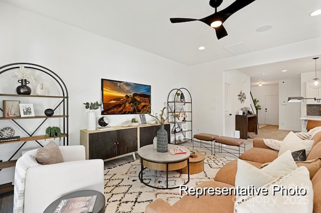 living room featuring light hardwood / wood-style flooring and ceiling fan