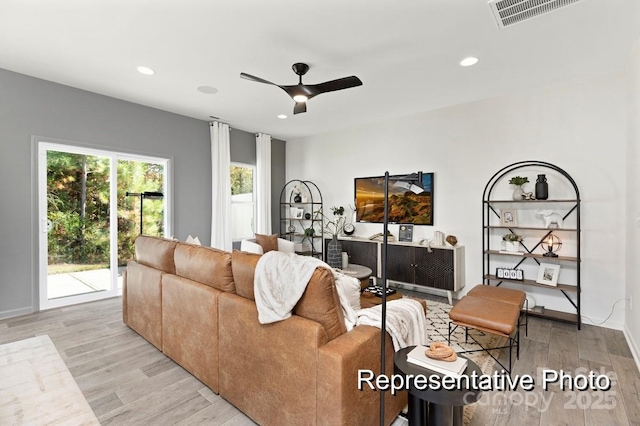 living room with ceiling fan and light hardwood / wood-style flooring