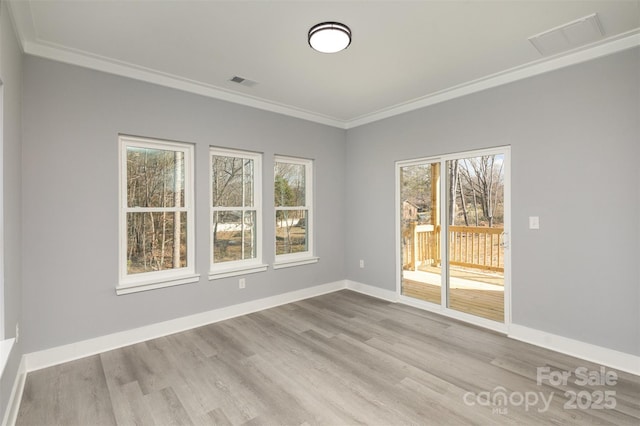 spare room with ornamental molding and light hardwood / wood-style flooring