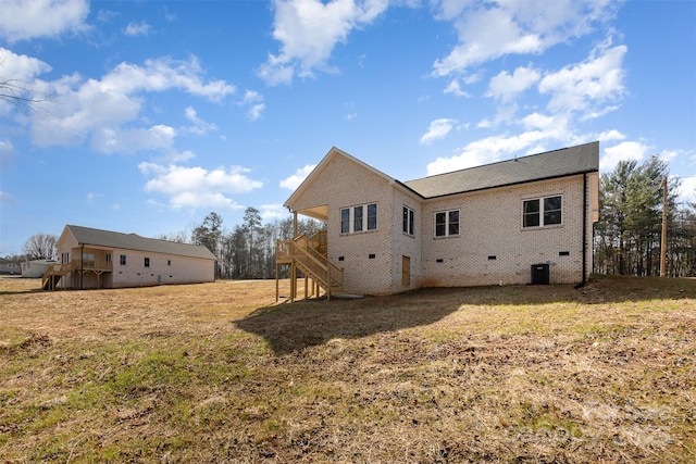 rear view of property featuring cooling unit and a yard