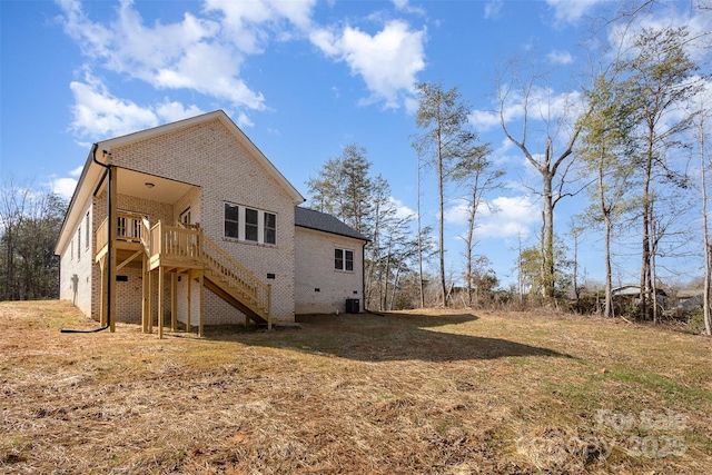 rear view of property with a wooden deck, cooling unit, and a lawn