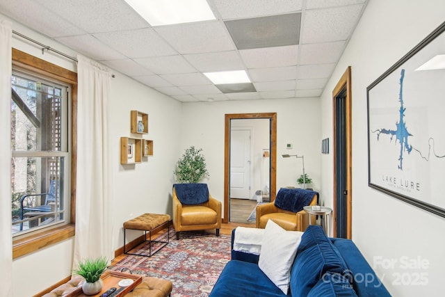 living room with hardwood / wood-style floors and a drop ceiling