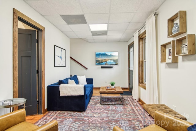 living room featuring hardwood / wood-style floors and a drop ceiling