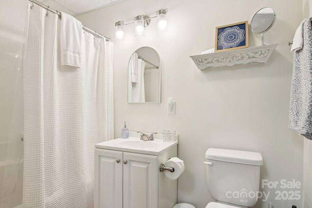 bathroom featuring walk in shower, vanity, and toilet