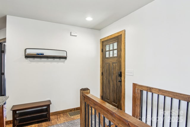 foyer with visible vents, baseboards, wood finished floors, and recessed lighting