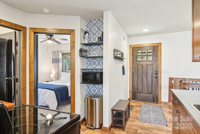 entryway featuring light wood-style flooring, stairway, ceiling fan, and recessed lighting