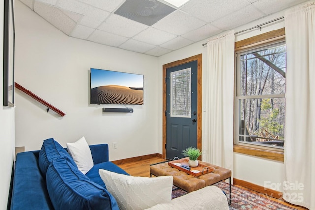 entrance foyer featuring a drop ceiling, baseboards, and wood finished floors