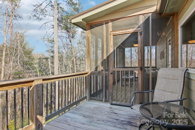 wooden deck with a sunroom