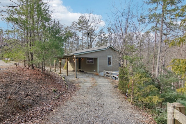 view of side of property with driveway and an attached carport