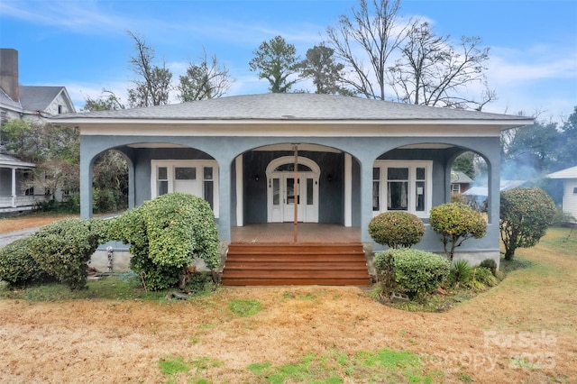 entrance to property featuring a yard and covered porch