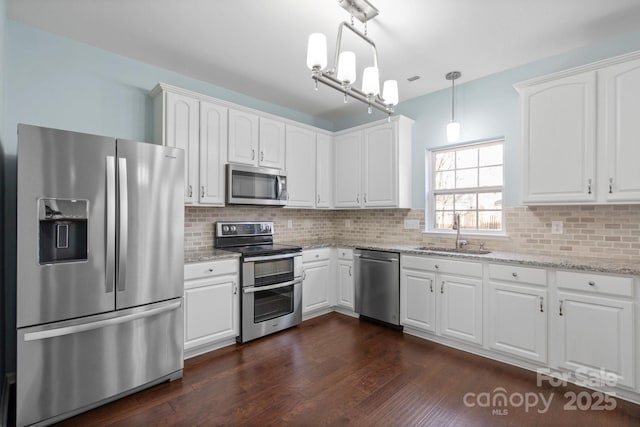 kitchen featuring sink, white cabinetry, pendant lighting, stainless steel appliances, and light stone countertops