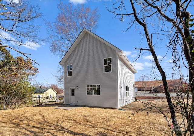 rear view of house featuring a patio area and a lawn