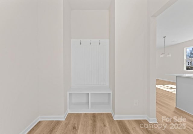 mudroom with light hardwood / wood-style flooring and a notable chandelier