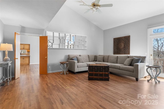 living room featuring ceiling fan, hardwood / wood-style floors, and high vaulted ceiling