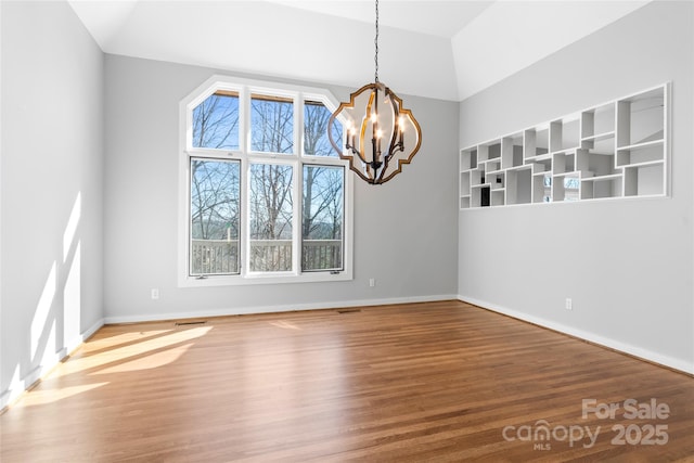 unfurnished dining area featuring an inviting chandelier, wood-type flooring, and vaulted ceiling