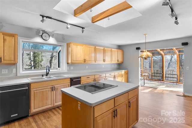 kitchen featuring light brown cabinetry, sink, a skylight, pendant lighting, and black appliances