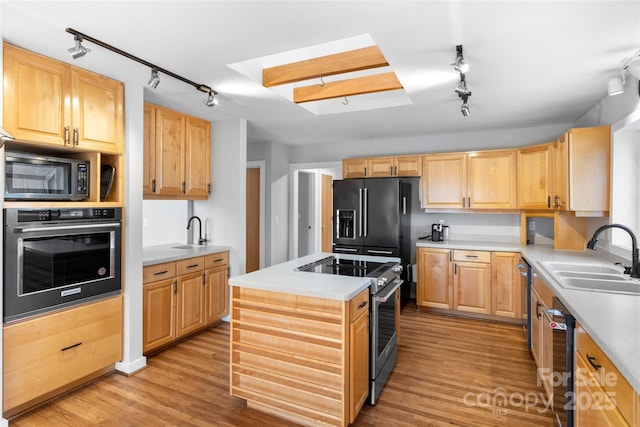 kitchen with sink, a center island, black appliances, light hardwood / wood-style floors, and light brown cabinetry