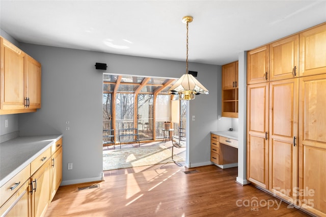 kitchen with hanging light fixtures, dark hardwood / wood-style floors, and light brown cabinetry